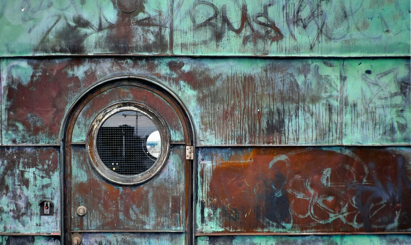 an old and rusty looking door with a round window