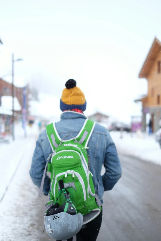 a man wearing a backpack walking down the street