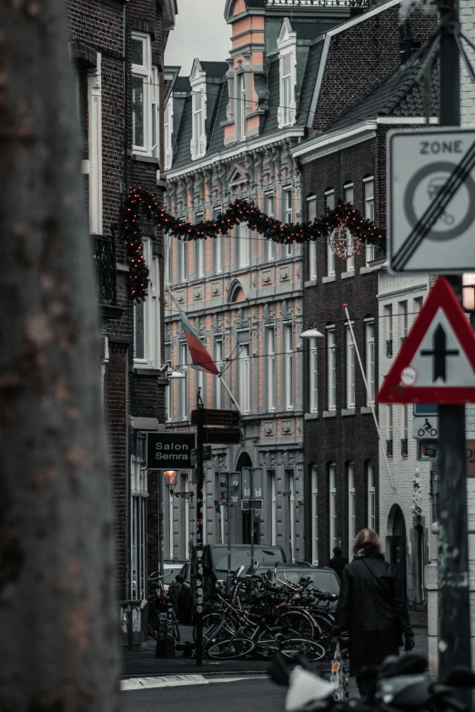 a city street is lined with buildings and buildings with christmas lights