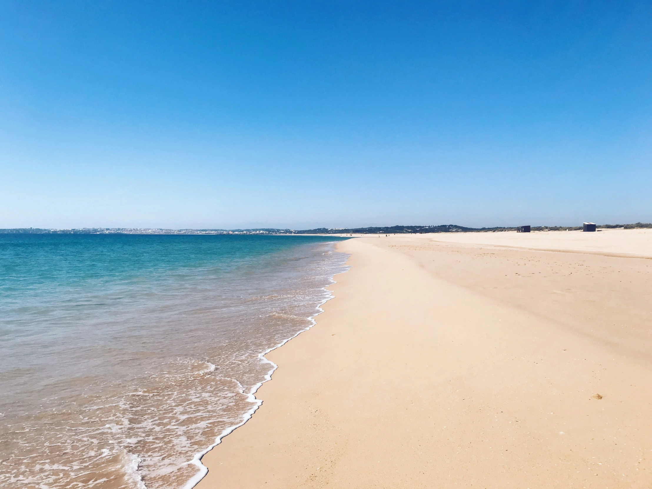 a blue body of water next to a beach