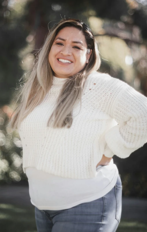 an attractive woman posing for a picture with her hands behind her head