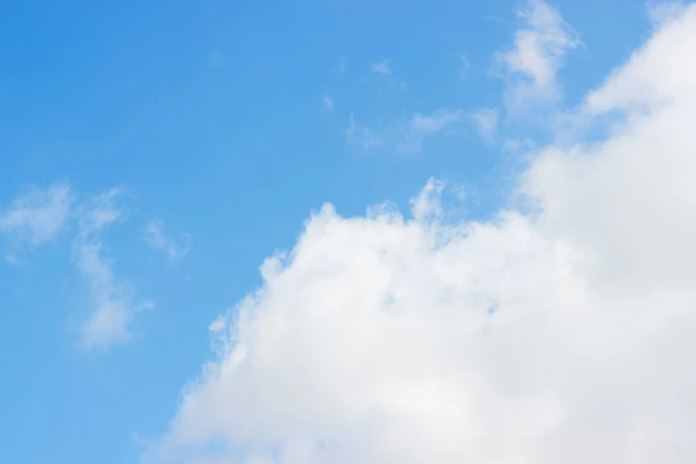 a blue sky with white clouds and a jet airplane in the middle