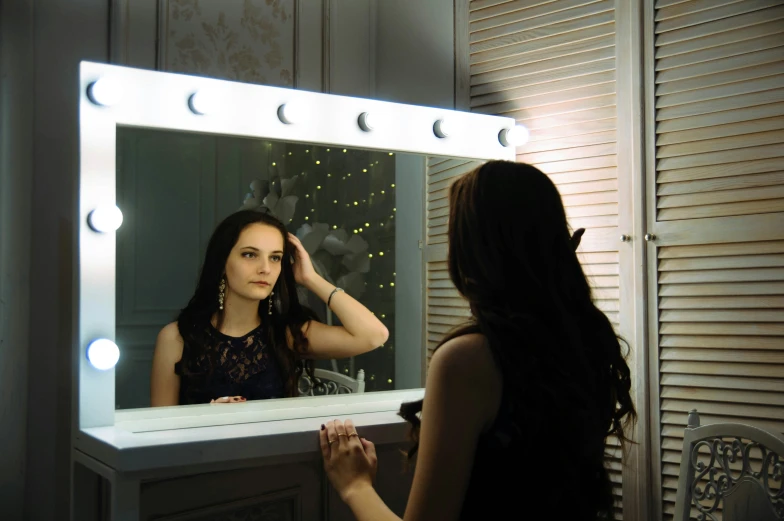 a woman standing in front of a mirror brushing her hair