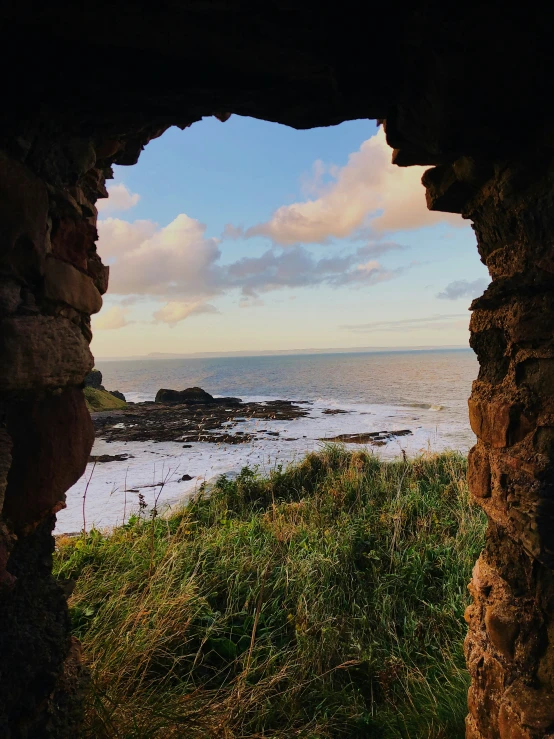 the view out of a window on a path near a beach