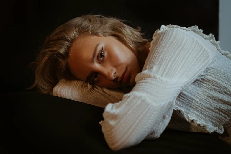 a model poses for a selfie while lying down