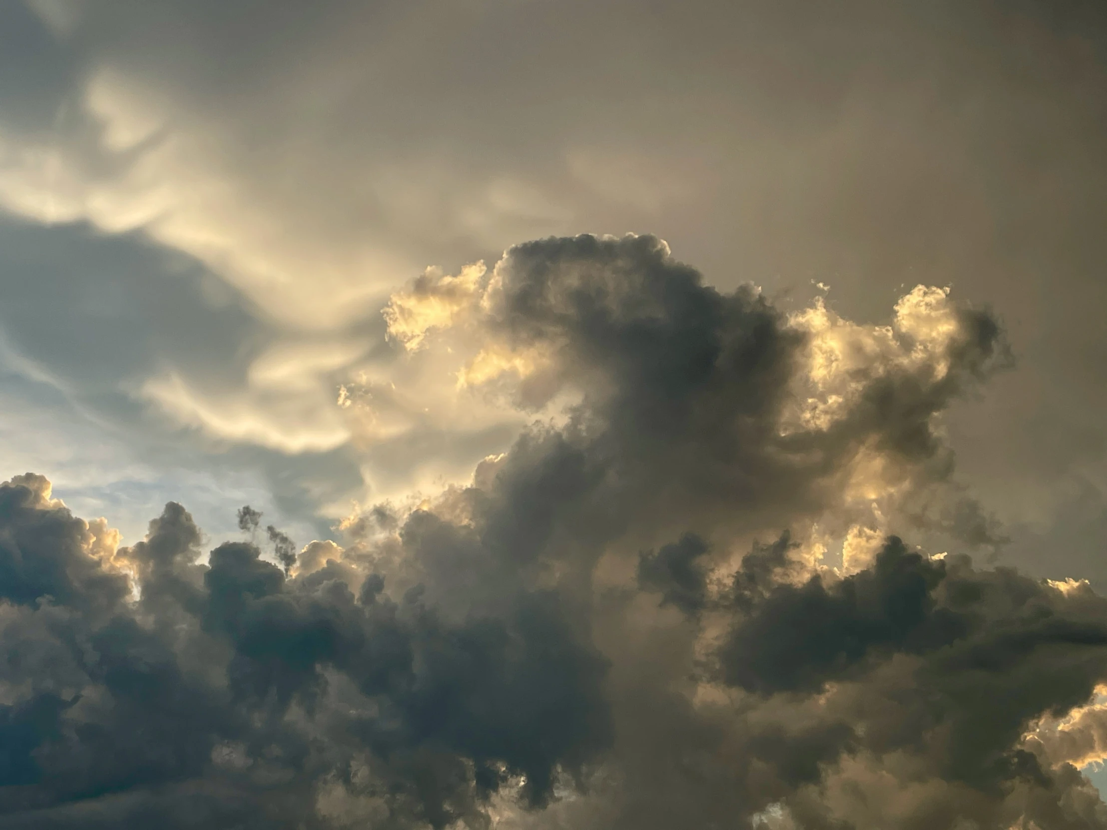 a big cloud with many gray clouds in the sky