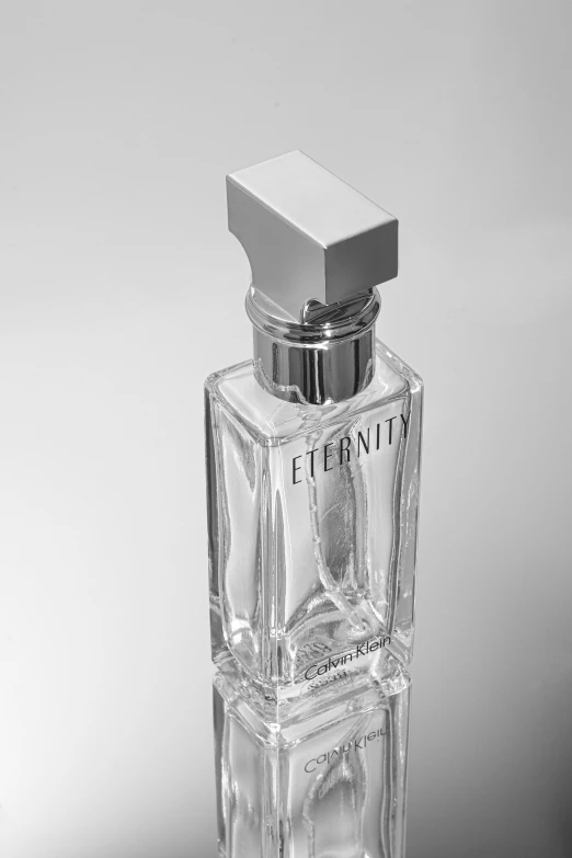 an empty bottle of perfume with a silver top