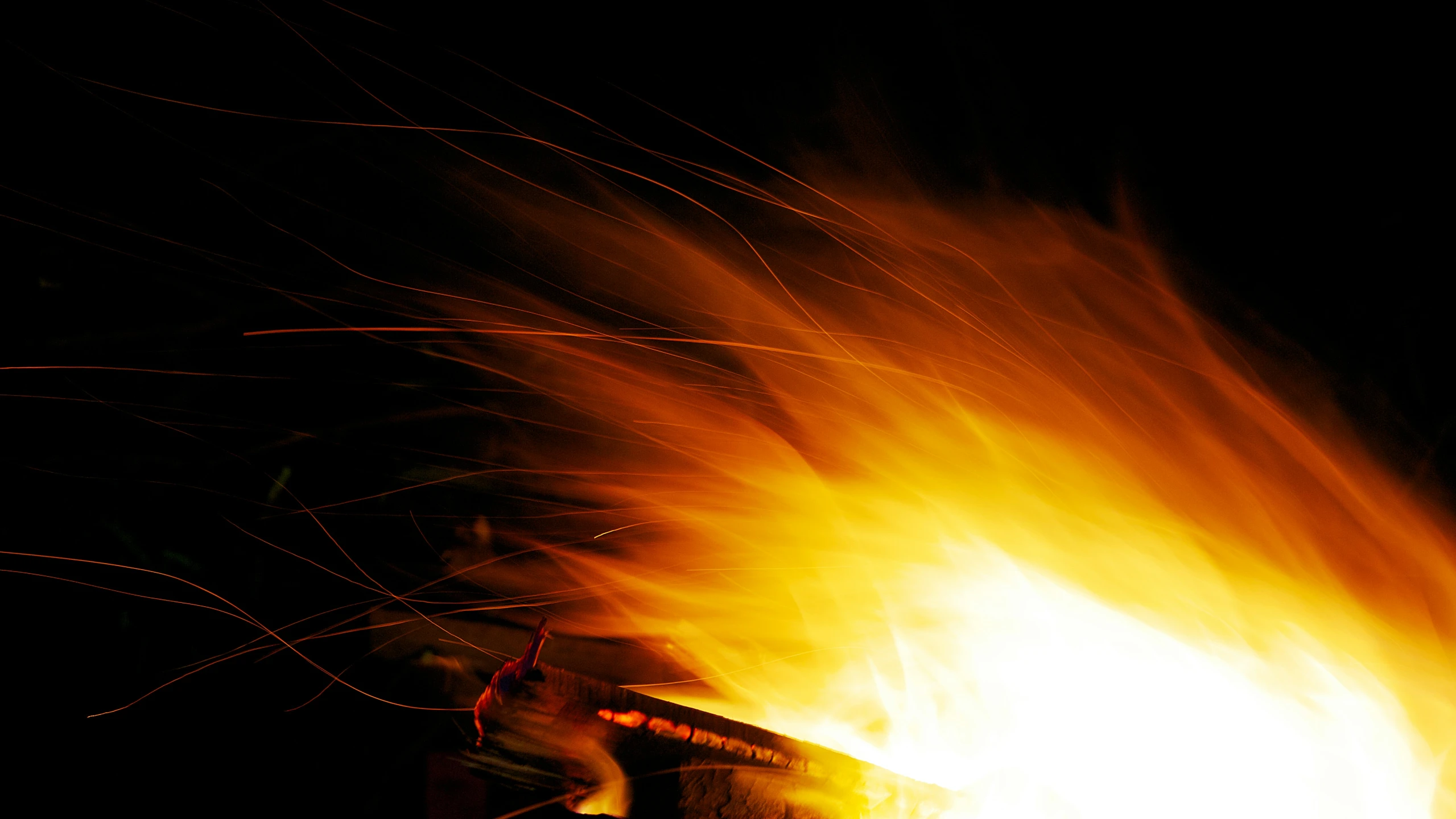 a person holding an open umbrella on top of a fire