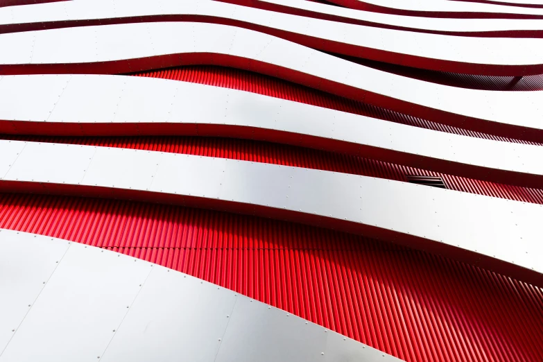 the curves of an exterior building with red and white walls