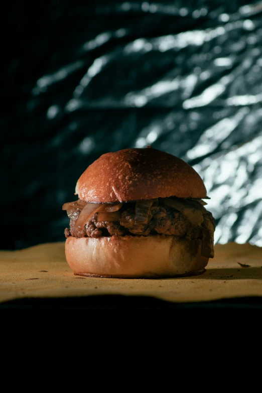 a close up of a hamburger in front of a black backdrop