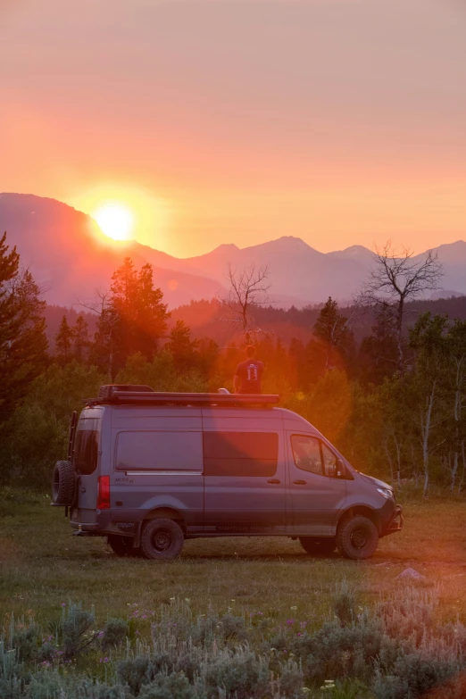 the van is parked with its trailer open while the sun sets