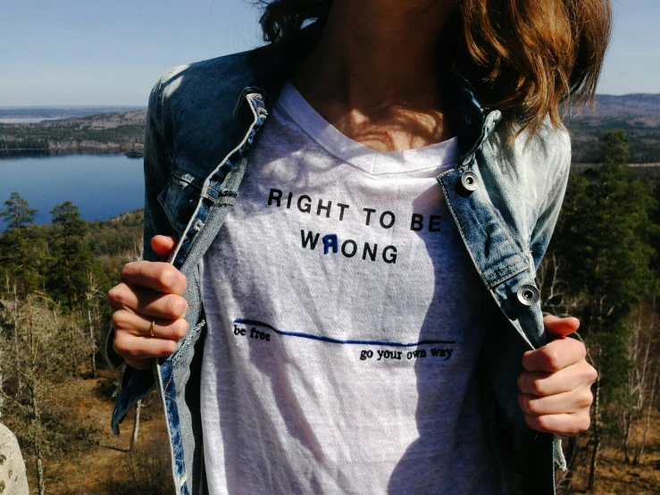 a women is holding her shirt open with the message right to wrong on it
