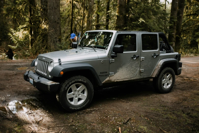 a jeep parked on the side of a forest road