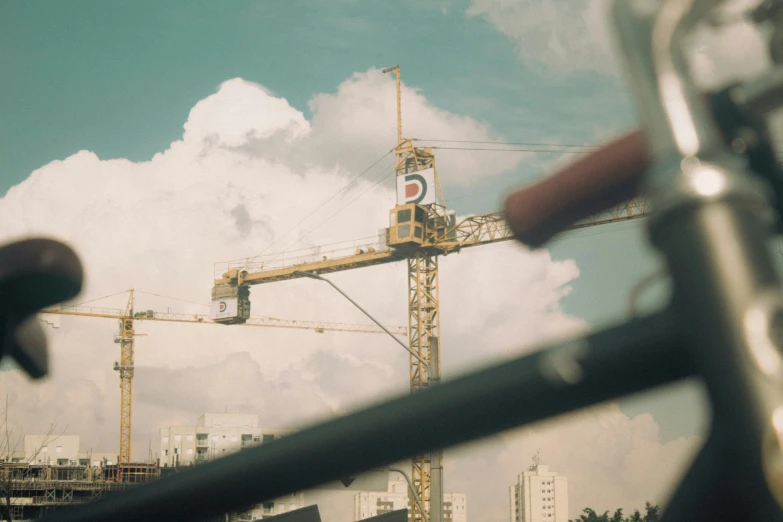 a tower crane in a large city under a cloudy sky