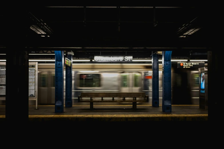 an empty platform with a bench and train on it