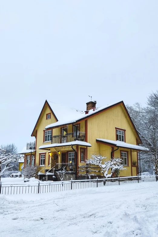 large yellow house in the middle of winter