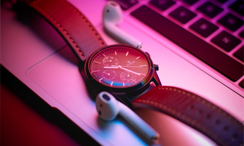 the watch is sitting next to a laptop