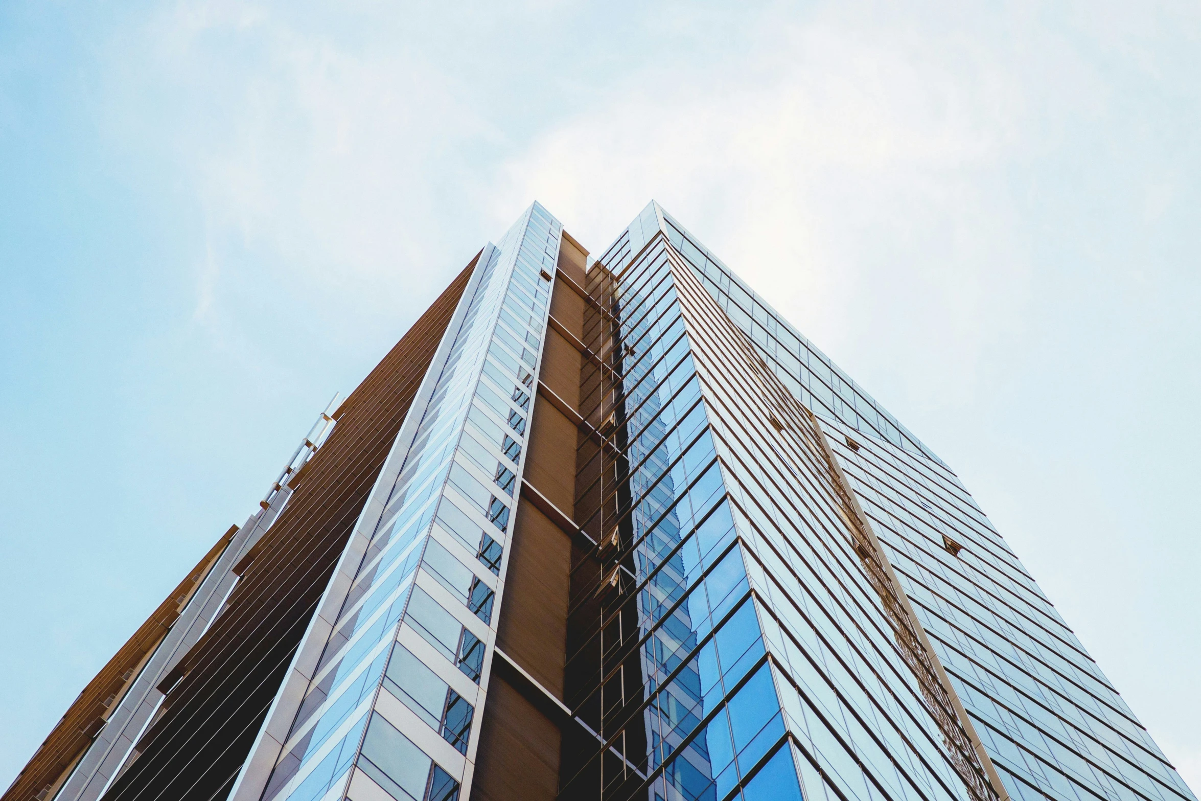 view from below of glass skyscr in a city