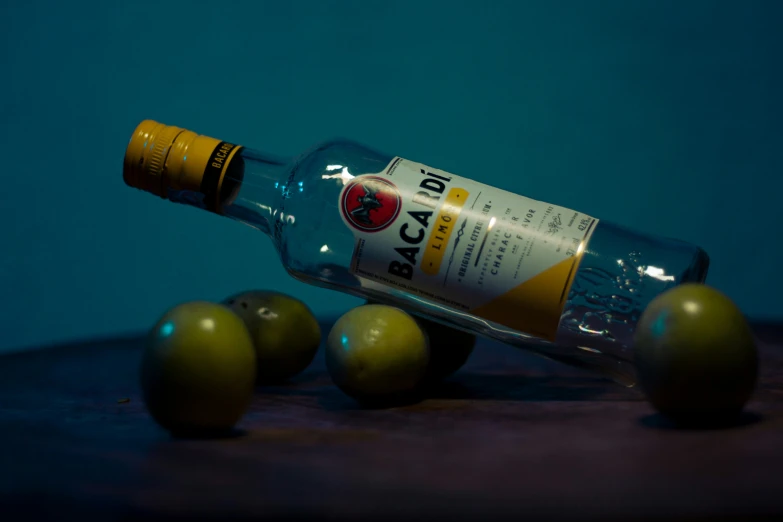 an unopened bottle of macallaine sitting on a table next to five apples