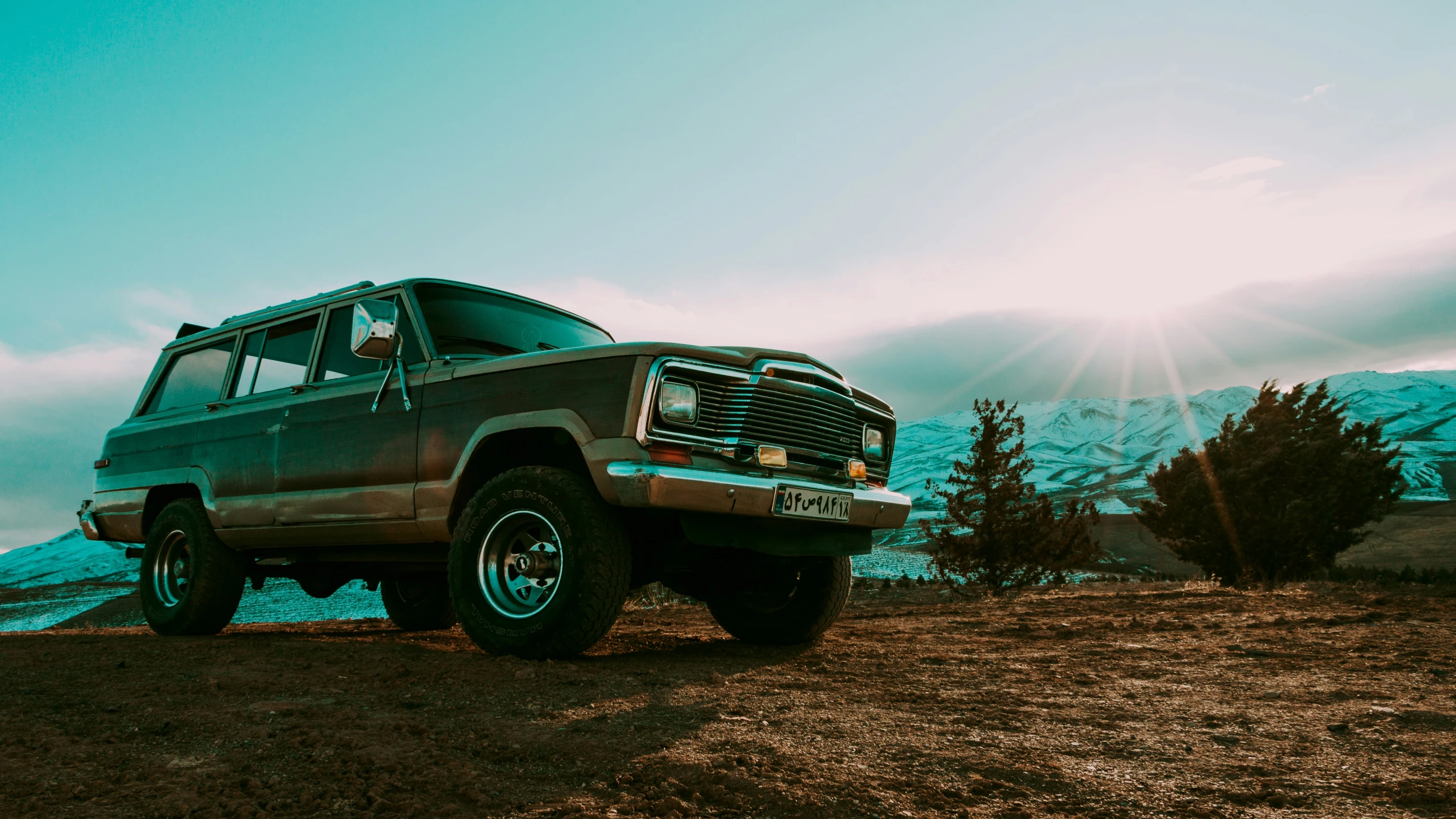 a pickup truck parked in the dirt near mountains