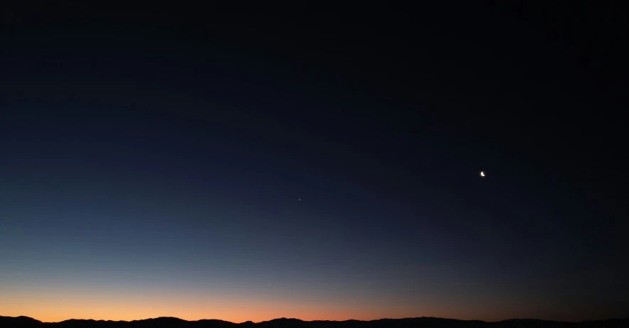 the sun setting over a mountain range with no clouds