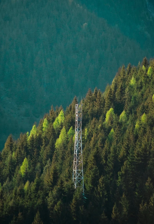 a small tower stands on top of a green hillside