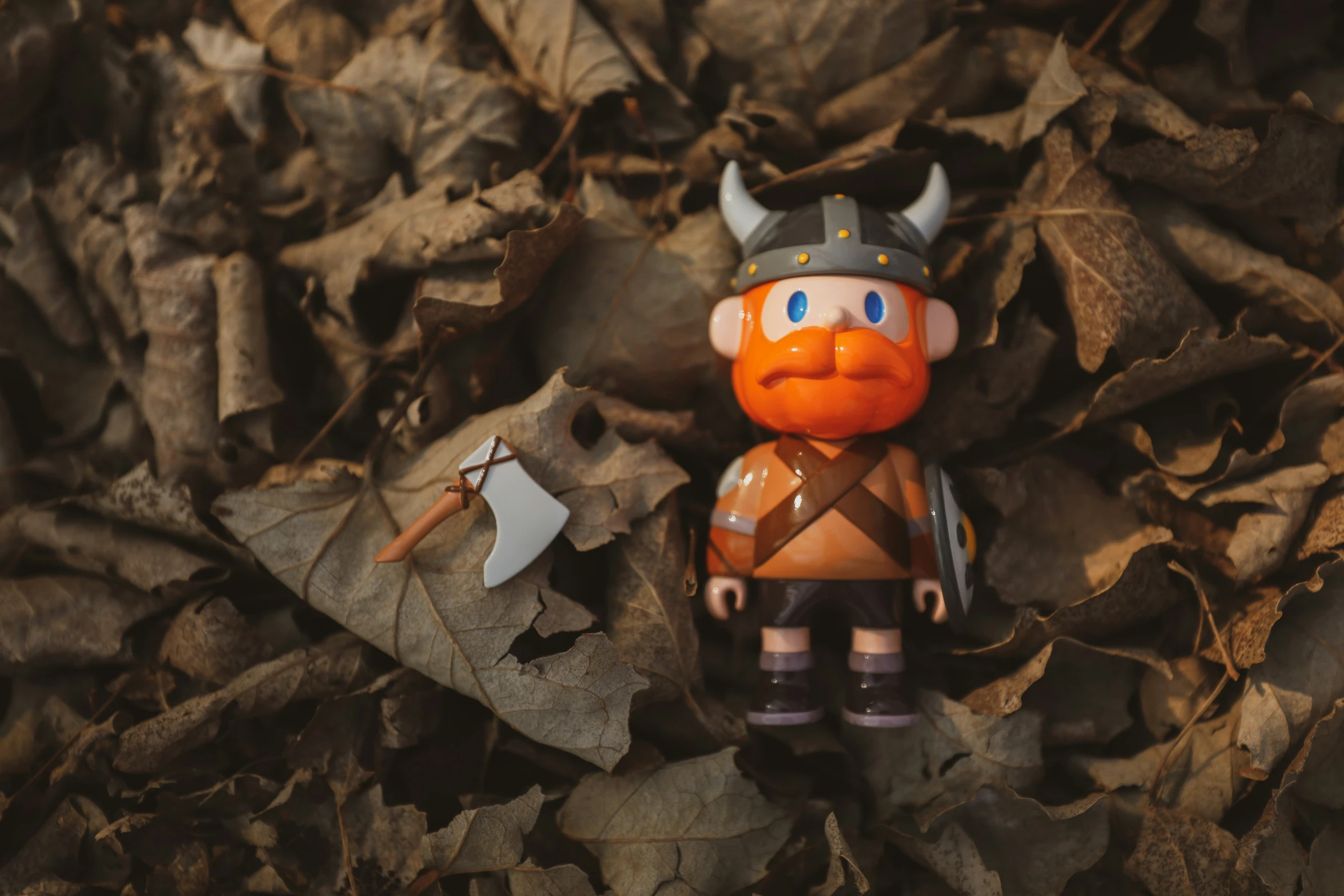 a toy sitting on top of leaves and dirt