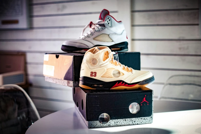 the air jordan 5 white cement in three different colors is sitting on top of two boxes