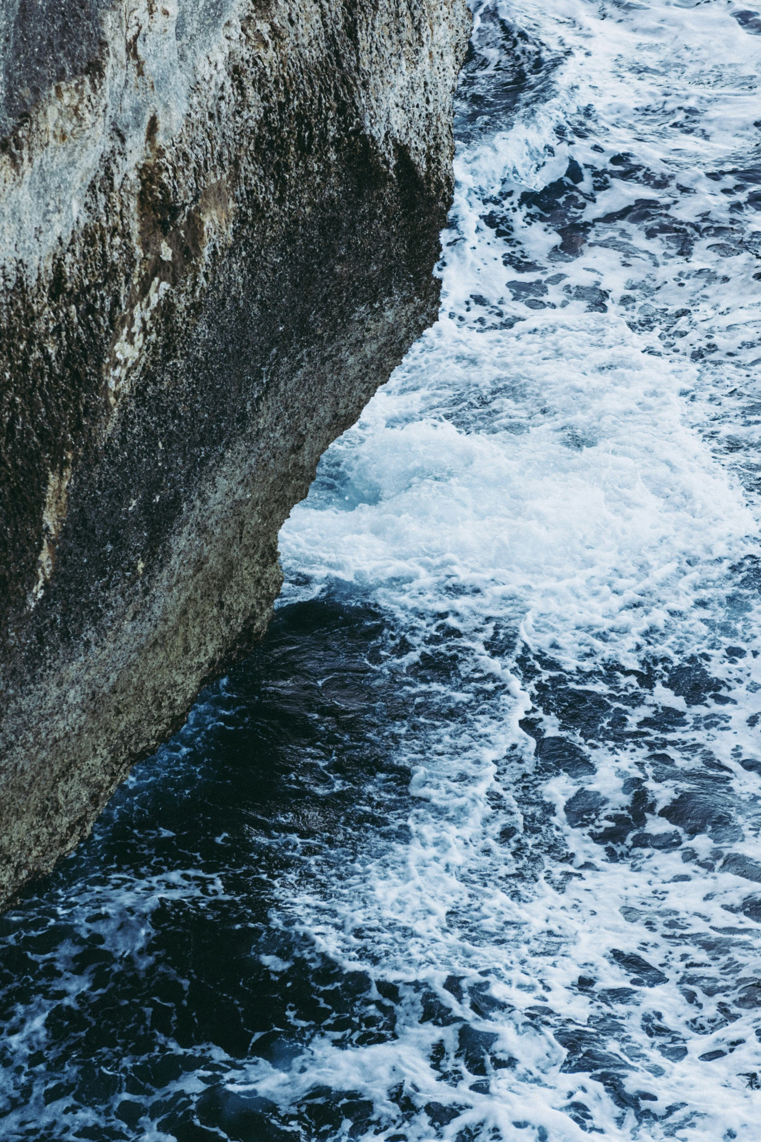 an ocean cliff sitting above the ocean near shore