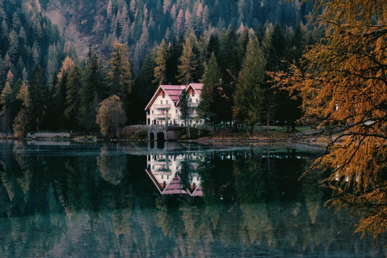 an old house sits beside a small lake