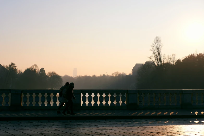 couple walking on bridge in the morning sun