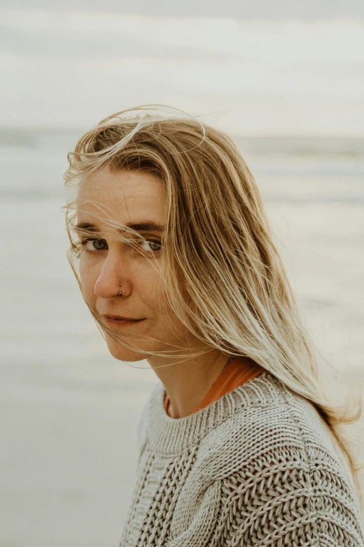 a woman sitting on a beach in front of the ocean