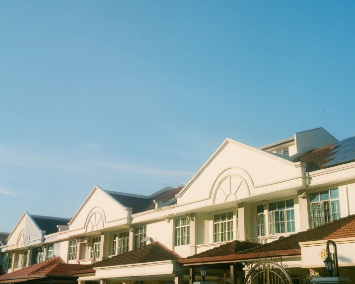 a row of white buildings with a clock on top