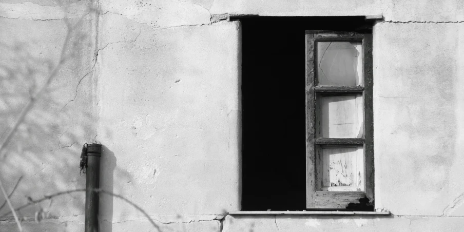 a window and a lamp on a white building