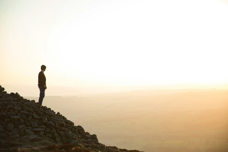 a person stands on top of a large rock