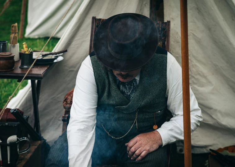 an older man in a hat is sitting on a chair