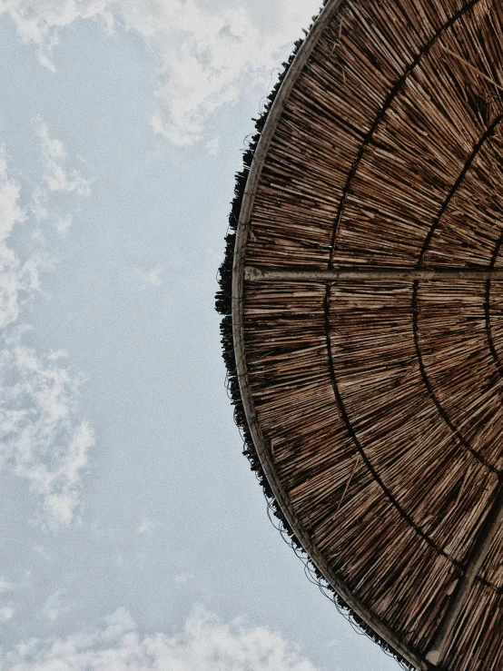 a bamboo umbrella is sitting under some blue sky