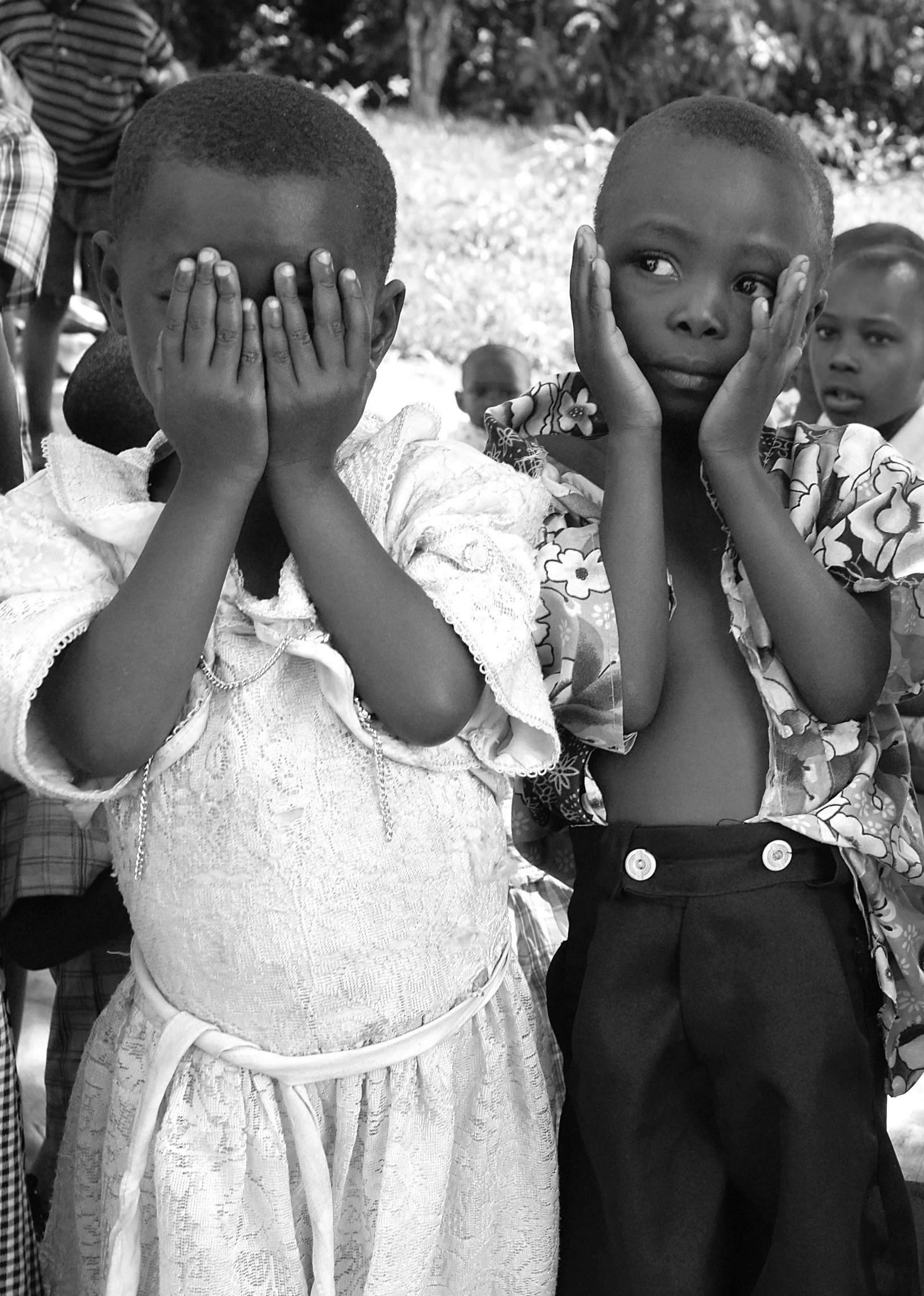 a group of s standing around each other covering their faces