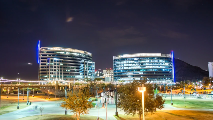 three skyscrs lit up at night in a city