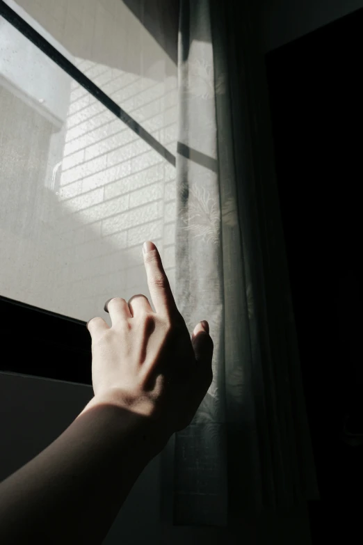 a person pointing a finger in the sun