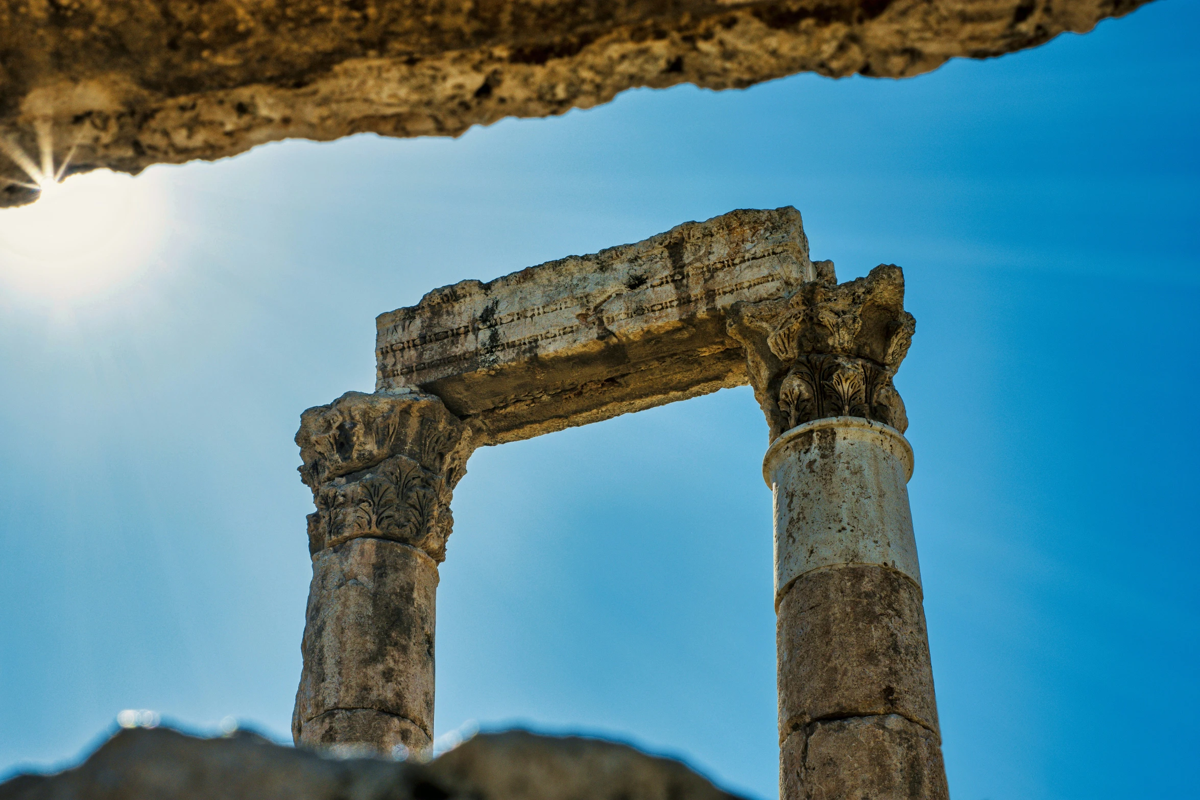 a group of ancient ruins sitting below the sun