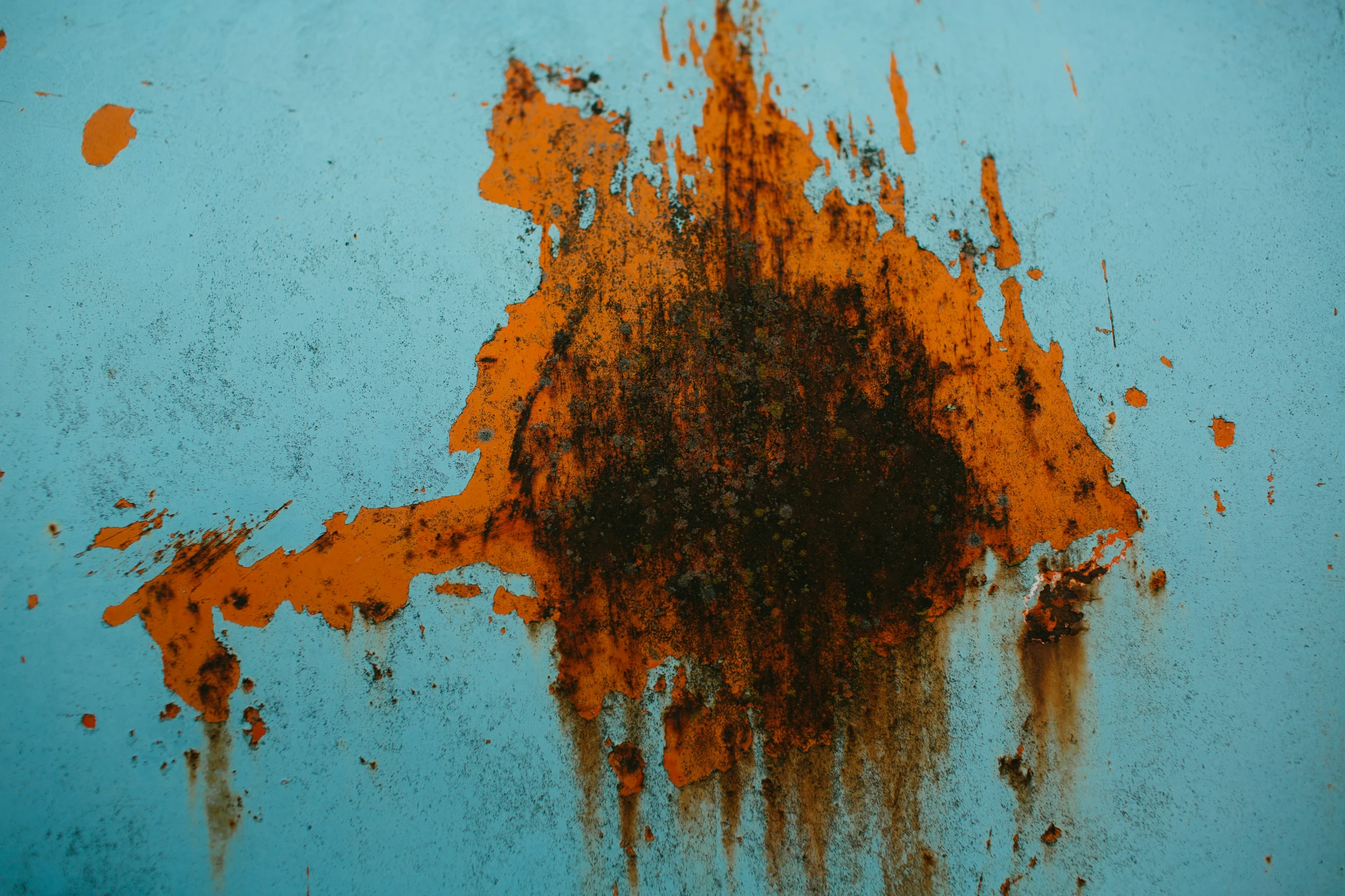 some orange and black stains are on a blue surface