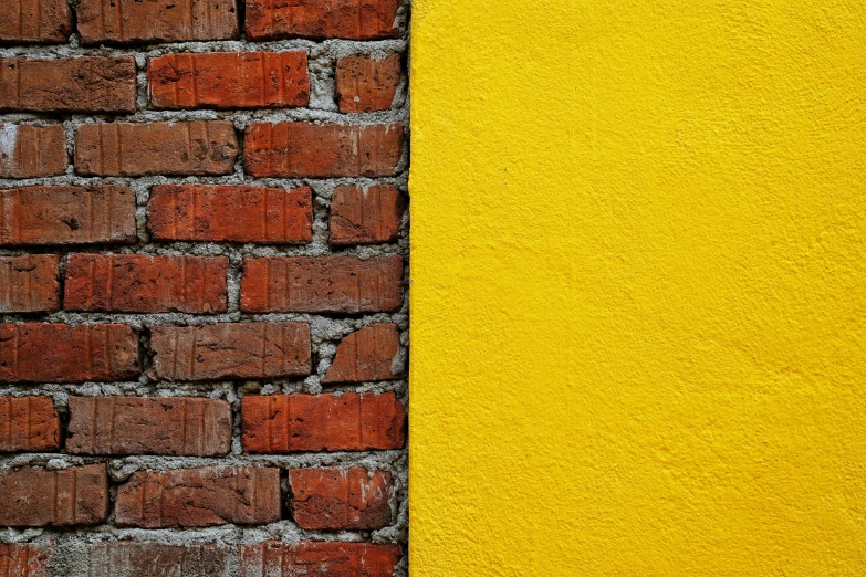 a yellow and red brick wall with a black edge