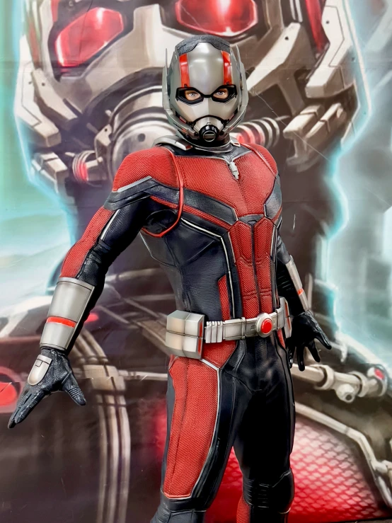 a ant man figure is posed next to a giant screen