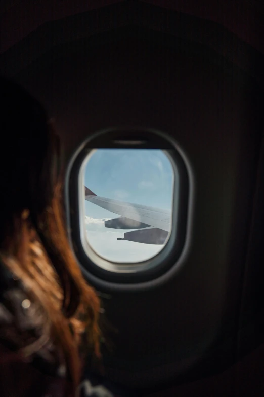 woman sitting in the back seat of an airplane looking out the window