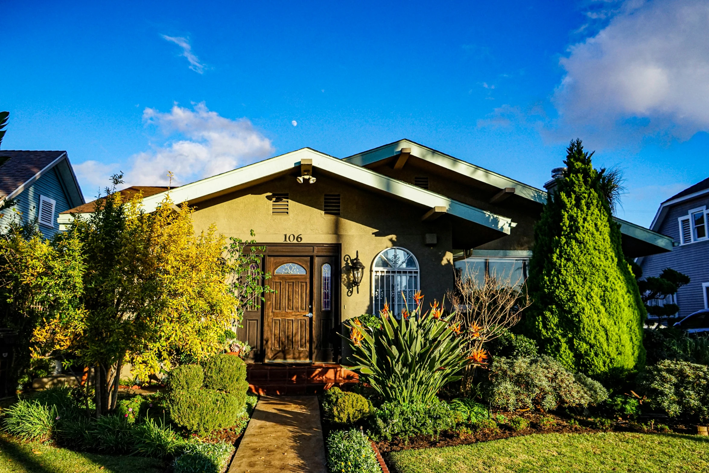 a house with bushes around the front