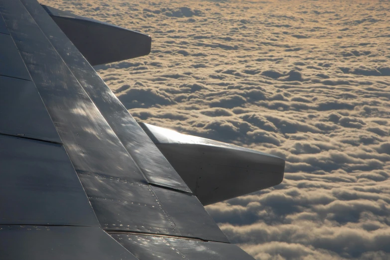 the view out an airplane window of some clouds and a plane wing