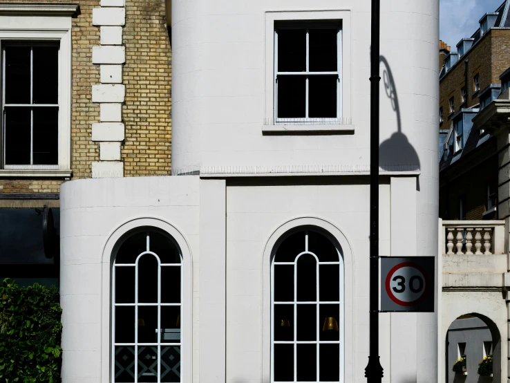 a white building with three windows in front of a street