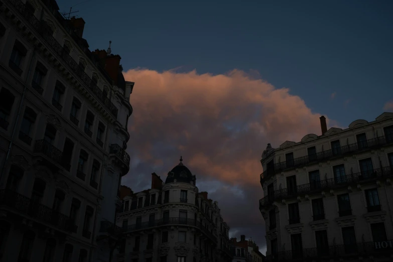 some very tall buildings near by with a cloud in the sky