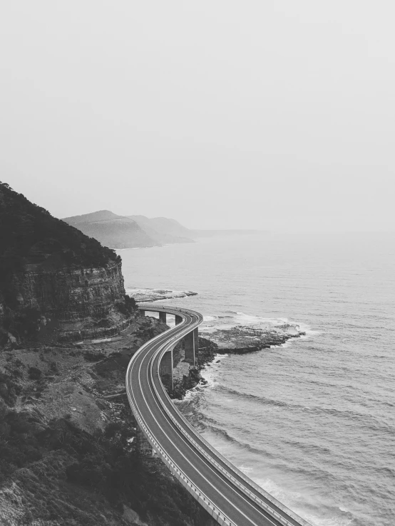 the view from a high viewpoint on an overpass to a winding road and ocean